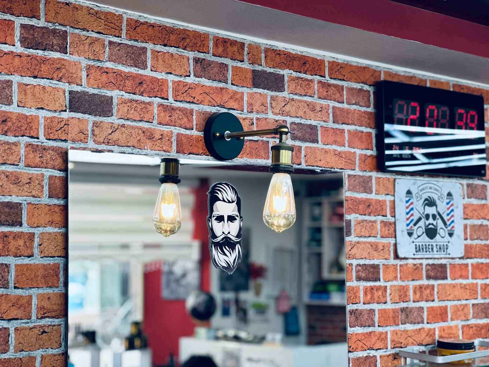 Ziegelwand im Salon mit Edison-Glühlampen, einem Barbier-Aufkleber am Spiegel und einem Blechschild Barber Shop
